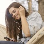 woman in white button up shirt while listening to music