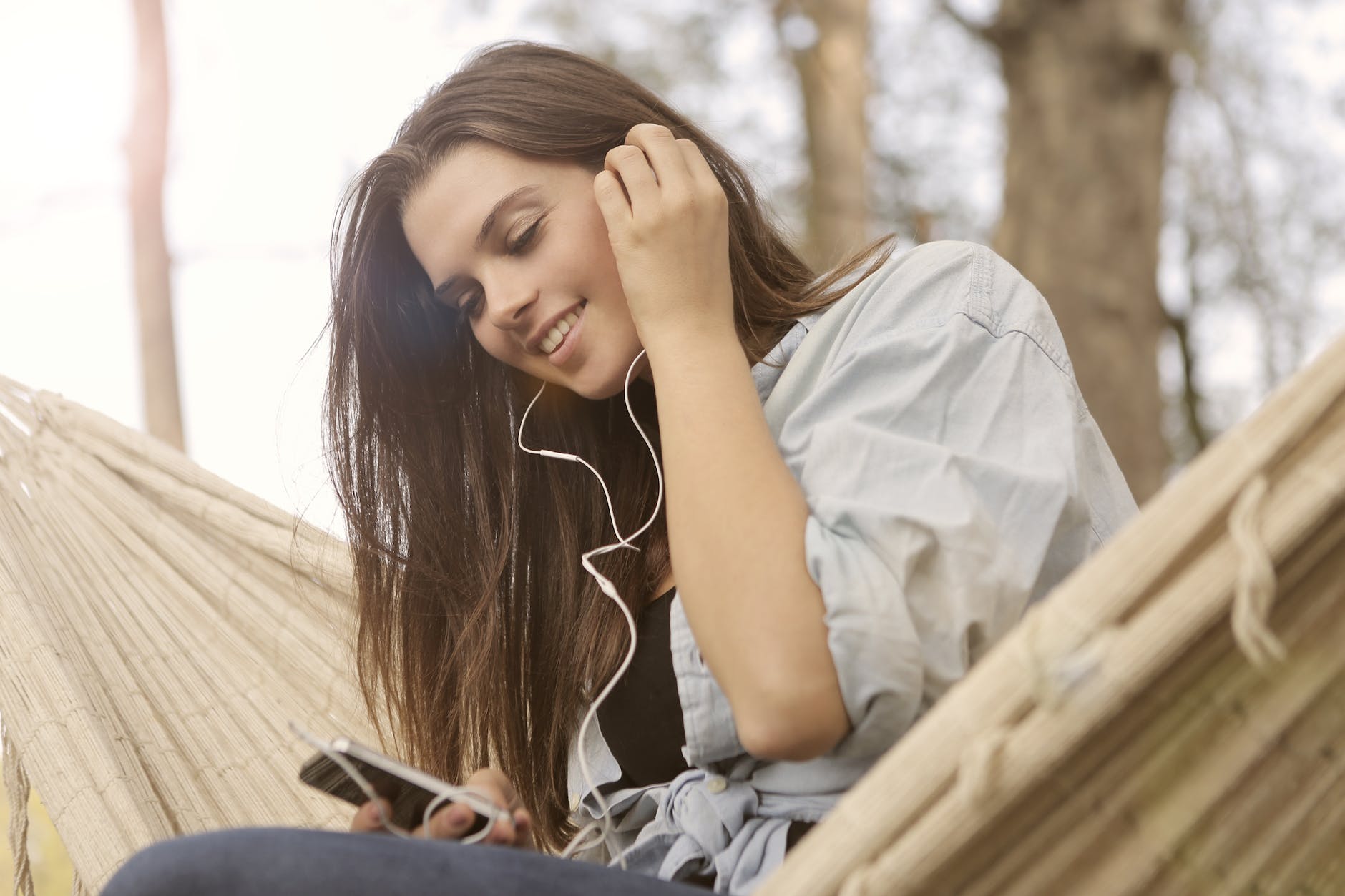 woman in white button up shirt while listening to music